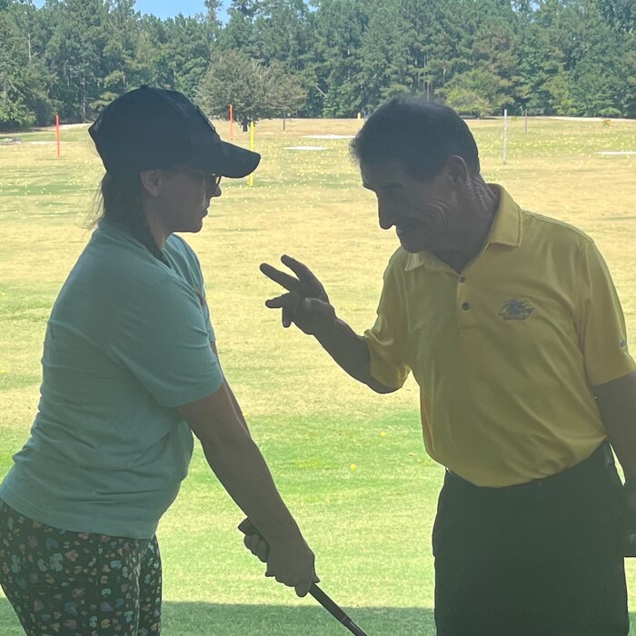 Marty Turcios talking with a participant on the driving range