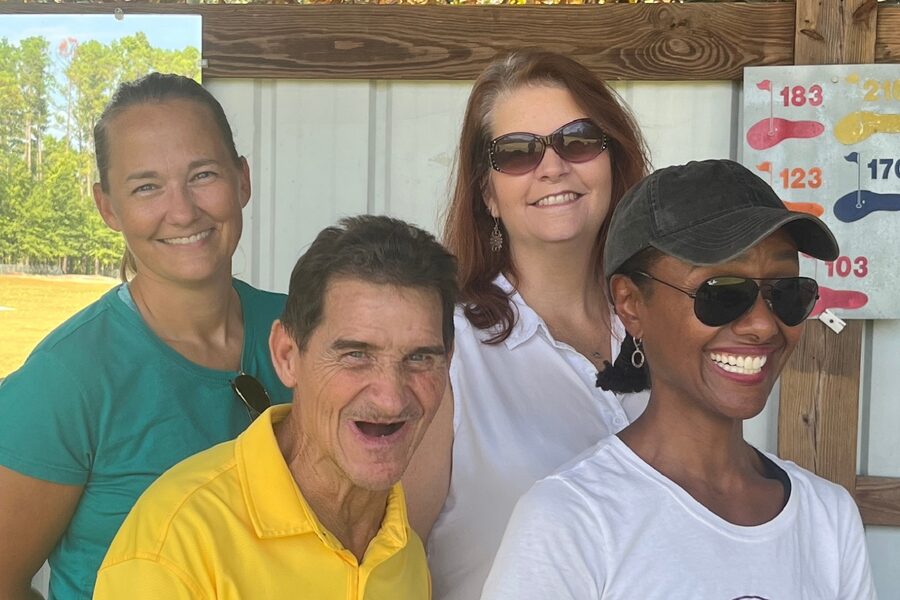 Marty Turcios with three members of the Functional Recovery Program therapist staff at Eisenhower Army Medical Center, smiling together at a driving range